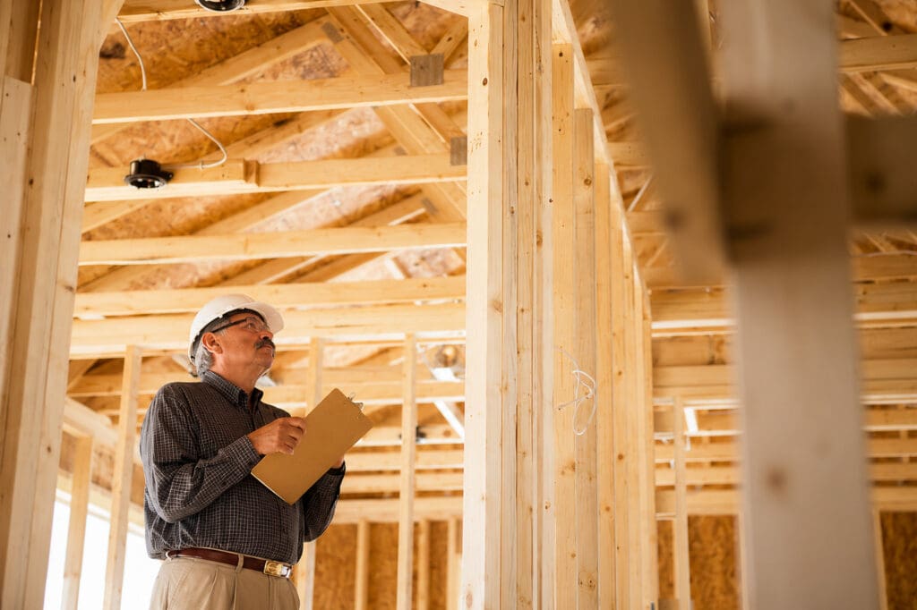 Home inspector reviewing framing and wiring during a pre-drywall inspection on a new construction home in Tampa Bay – Elena Esquen Relocation Expert